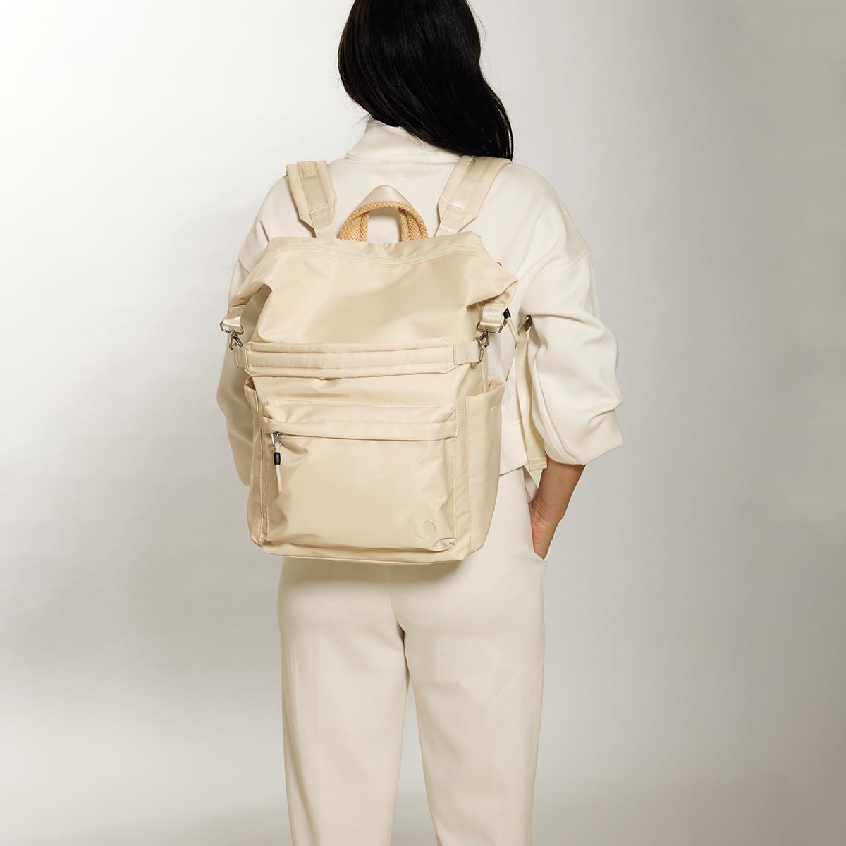 Practice Karma Medium Backpack in Tofu cream color on model in cream clothing
