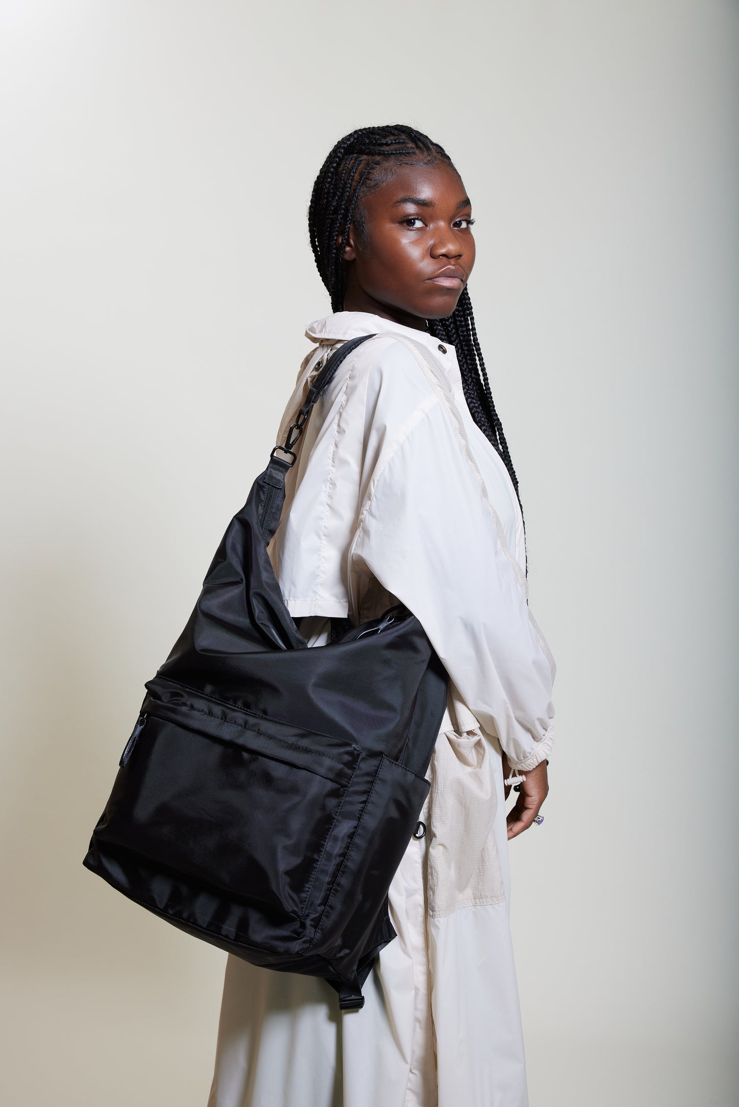 Female model wearing Karma Black Backpack as a shoulder bag