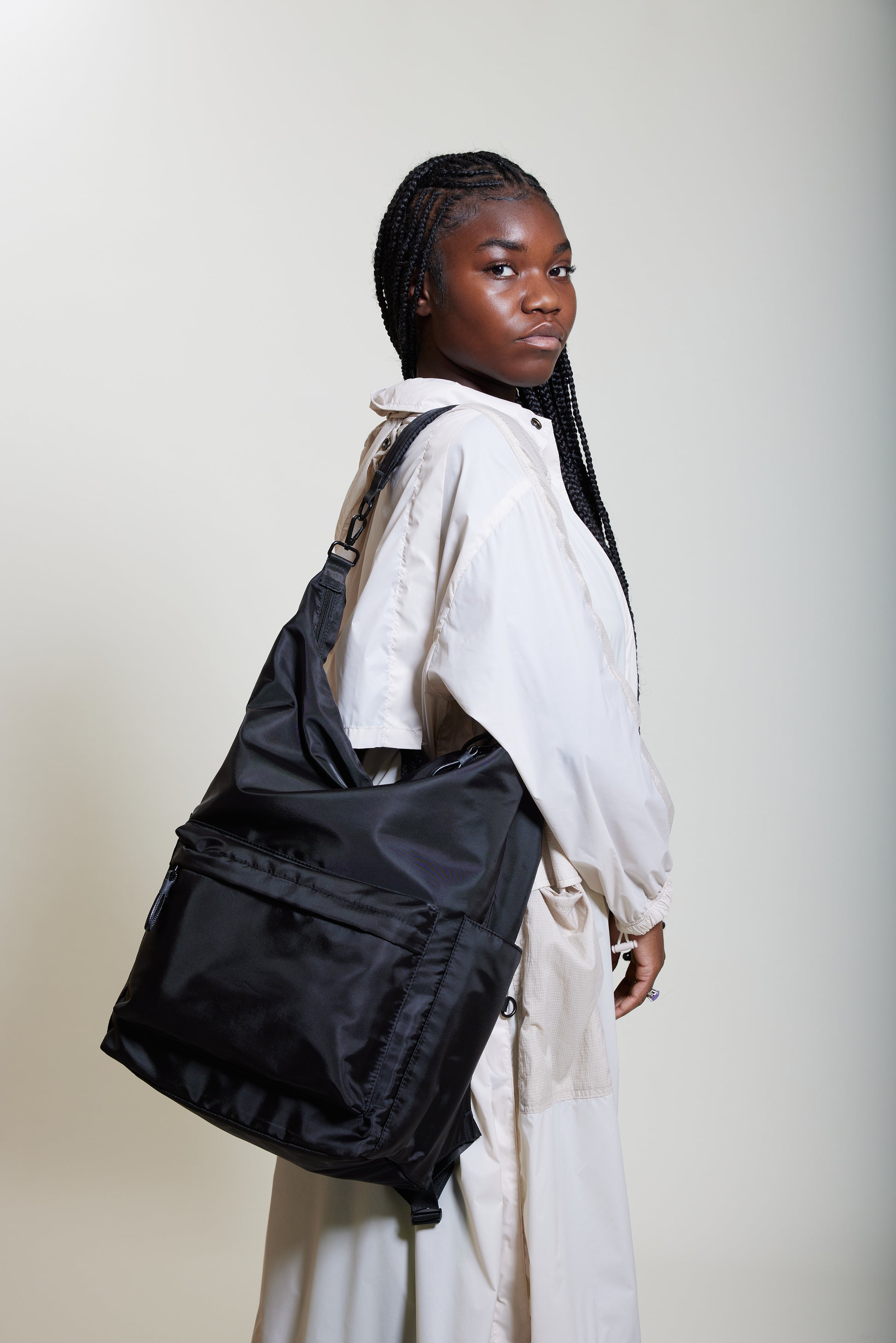 Female model wearing Karma Black Backpack as a shoulder bag