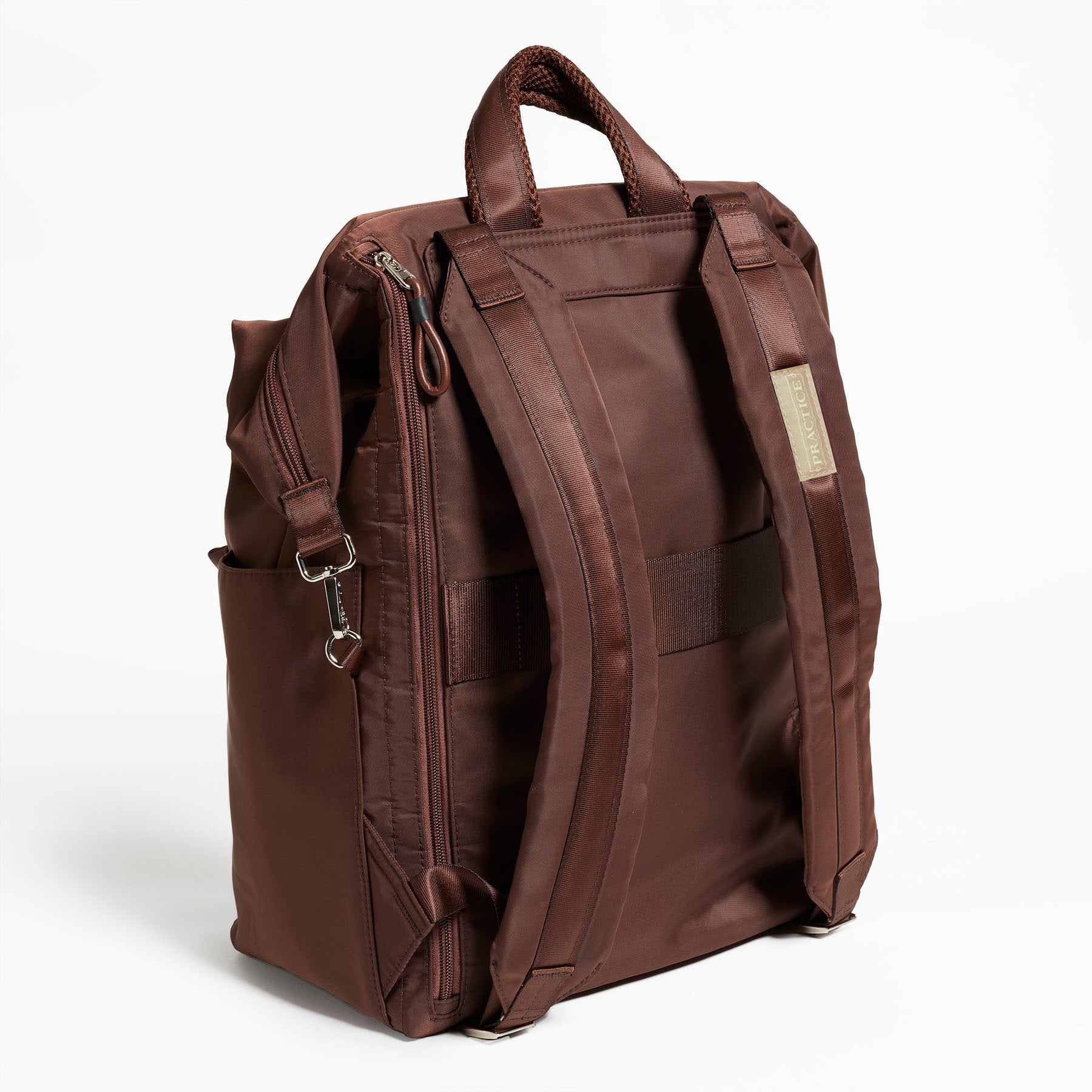 Back Facing view of the Karma Backpack in Mushroom Brown Nylon. Backpack has a top handle and a convertible strap to carry your backpack as a tote for easy grab and go! Back side has back zipper for easy access to your laptop, a trolley sleeve for easy travel on top of your luggage, and 2 comfy backpack shoulder straps