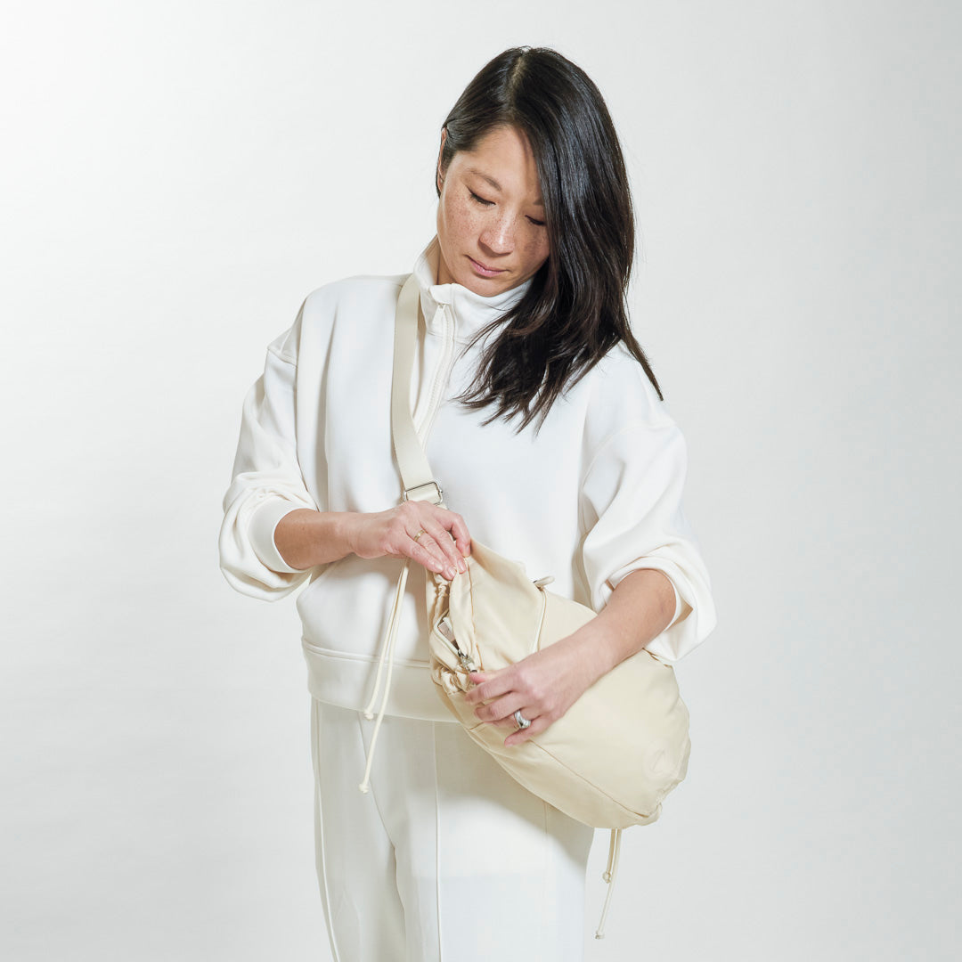 Practice Demilune Shoulder Sling bag in Tofu cream color on model in white clothes