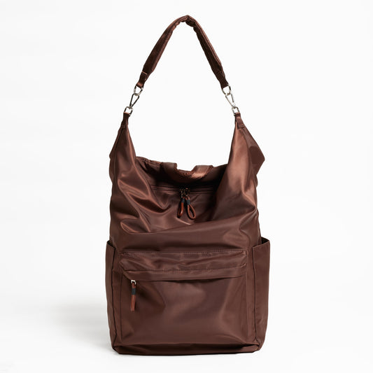 Front Facing view of the Karma Backpack in Woodland Brown Nylon. Backpack has a top handle and a convertible strap to carry your backpack as a tote for easy grab and go!