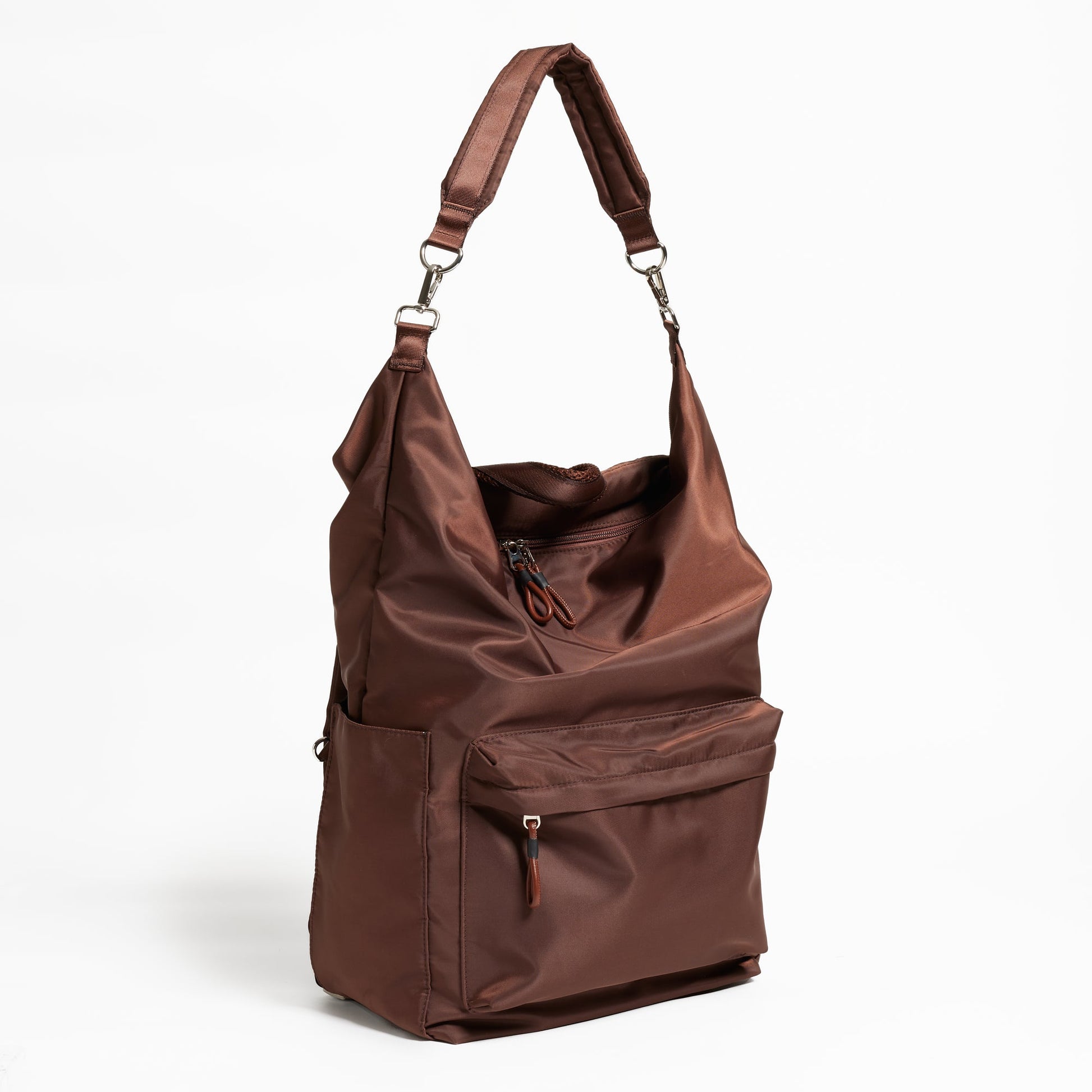 Front Facing view of the Karma Backpack in Woodland Brown Nylon displayed as a slouchy shoulder bag. Backpack has a top handle and a convertible strap to carry your backpack as a tote for easy grab and go!
