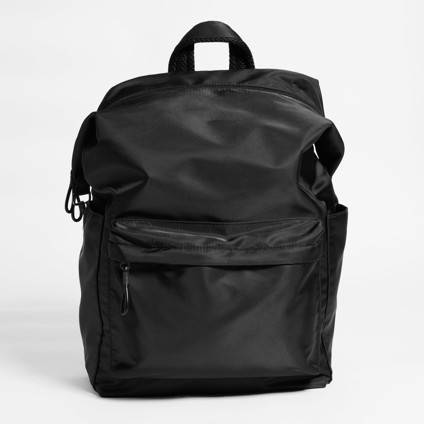 Front Facing view of the Karma Backpack in Black Nylon. Backpack has a top handle and a convertible strap to carry your backpack as a tote for easy grab and go!